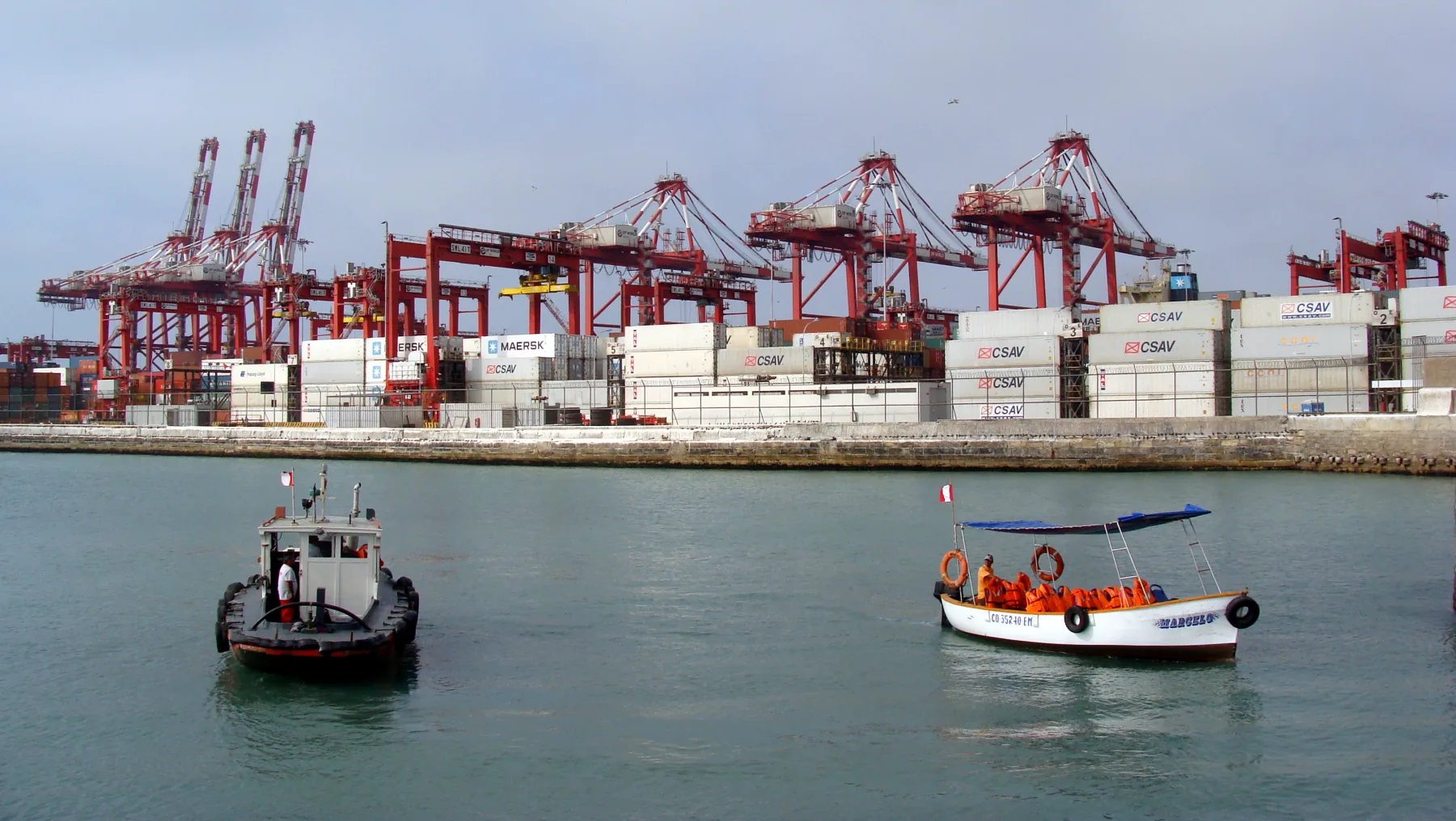 Container cranes and two small boats in the Port of Callao, photographed in 2013.
